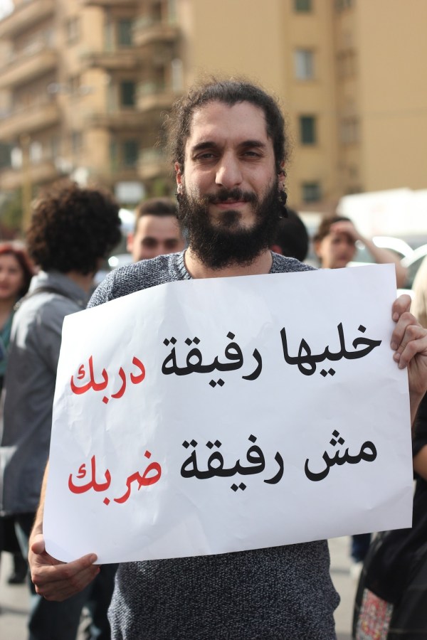 Nizar Najjar, 28, holds a sign that reads, "Make her a partner in your path, not a partner for your beating."